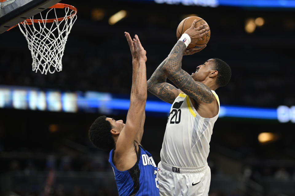 Utah Jazz forward John Collins (20) goes up to shoot as Orlando Magic guard Caleb Houstan (2) defends during the second half of an NBA basketball game, Thursday, Feb. 29, 2024, in Orlando, Fla. (AP Photo/Phelan M. Ebenhack)