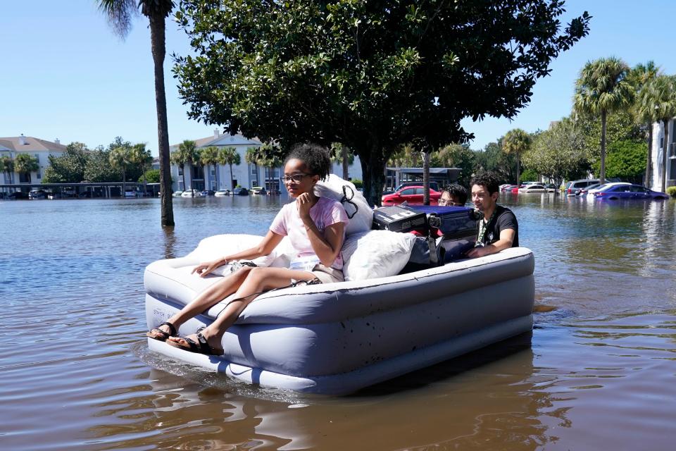 University of Central Florida students use an air mattress to leave a flood apartment complex in Orlando on Friday (AP)