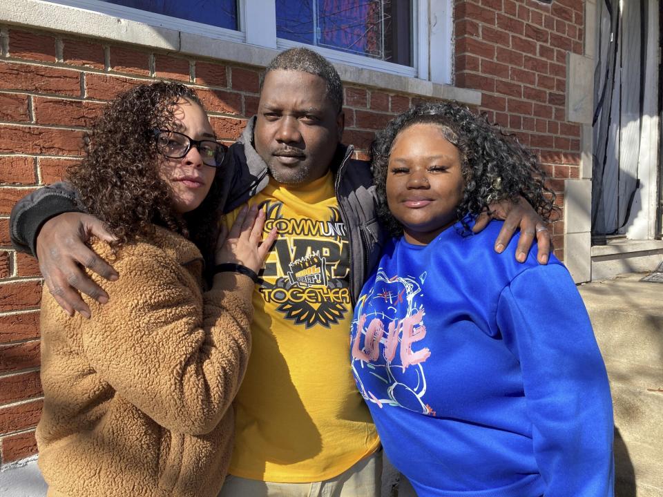 McKynzi Douglas, right, stands with her parents, John and Janay Douglas, outside their home on Thursday, Jan. 26, 2023, in St. Louis, Mo. McKynzi and other students of Central Visual and Performing Arts High School in St. Louis recently returned to school for the first time since fleeing from a shooting last October that killed two and wounded seven. (AP Photo/Jim Salter)