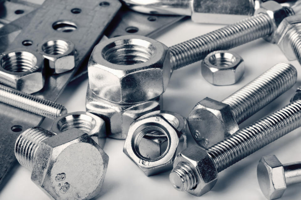 Close up of shiny industrial fasteners and assorted nuts and bolts.