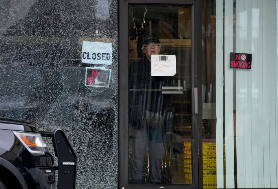 A man looks out the window of Tokyo Foods on Reading Road in Evendale on Monday, January 23, 2023, a day after a man was arrested after police say he fired several shots into the business.