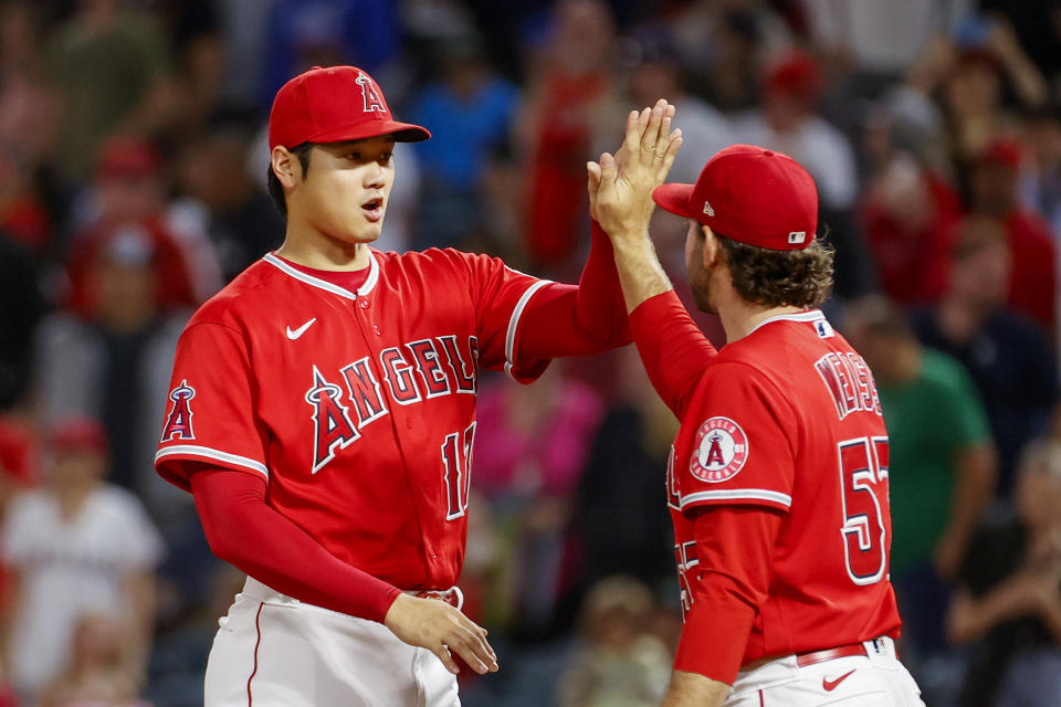 Los Angeles Angels' Shohei Ohtani, left, celebrates with pitcher Zack Weiss after the team's win over the Texas Rangers in a baseball game in Anaheim, Calif., Saturday, Oct. 1, 2022. (AP Photo/Ringo H.W. Chiu)