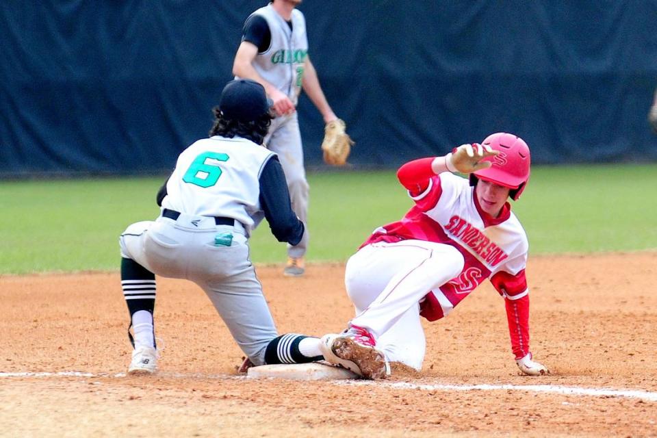 Sanderson High School’s Caleb Kleven (right) slides into third base ahead of the tag by Cardinal Gibbons High’s Drew Sotell (6) in this 2018 file photo.