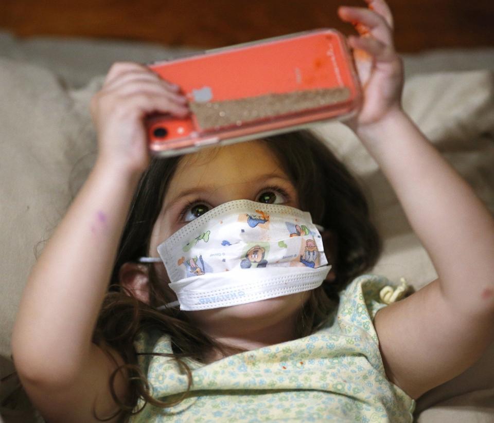 Stella Detwiler wears a mask to protect David Detwiler during his dialysis. (Jeff Lange)