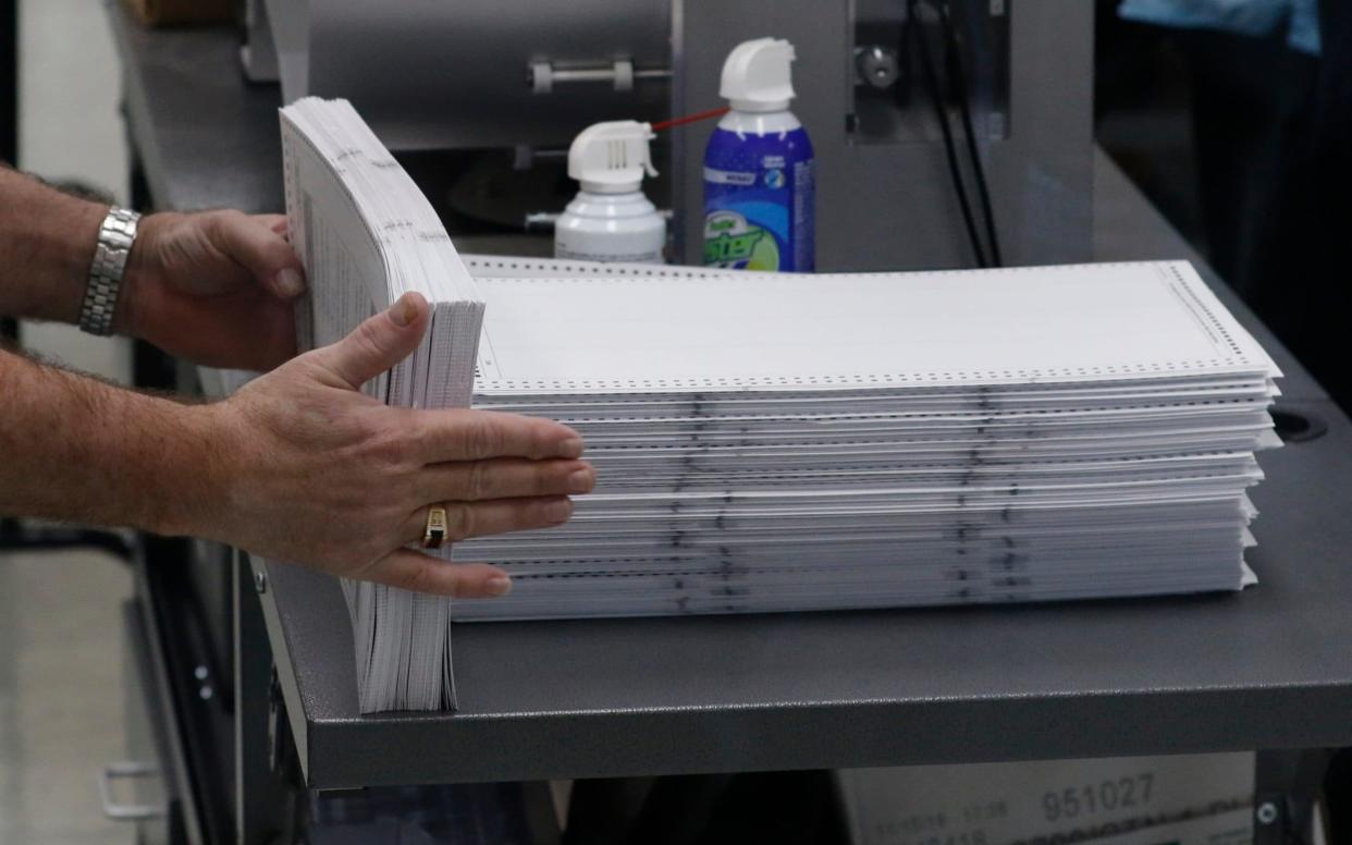 Elections staff load ballots into machine as recounting begins at the Broward County Supervisor of Elections Office  - Getty Images North America
