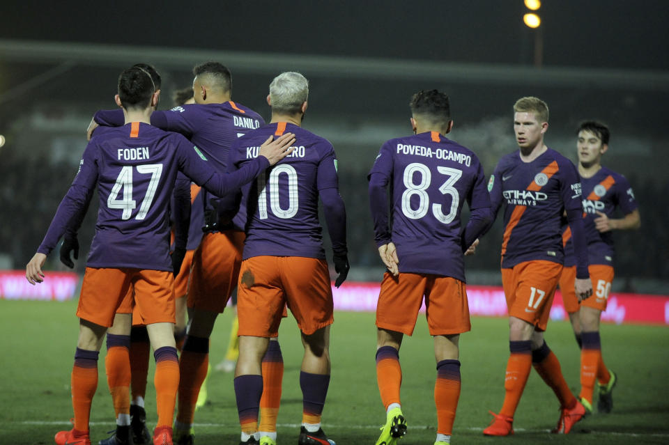 Manchester City's Sergio Aguero, 10, celebrates scoring his side's first goal with teammates including Manchester City's Kevin De Bruyne, second right, during the English League Cup semifinal soccer match between Burton Albion and Manchester City at Pirelli Stadium in Burton on Trent, England, Wednesday, Jan. 23, 2019. (AP Photo/Rui Vieira)