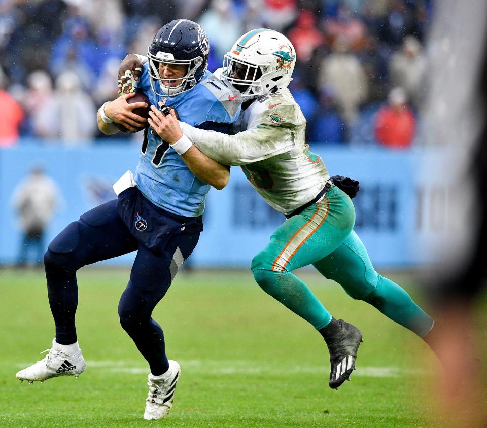 Dolphins linebacker Jerome Baker tackles Titans quarterback and former teammate Ryan Tannehill.