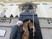 A woman's right activist holds a sign saying "nie"'or "no" in front of a church to protest new restrictions on abortion In Poland, in Warsaw, Poland, Sunday, Oct. 25, 2020.(AP Photo/Czarek Sokolowski)