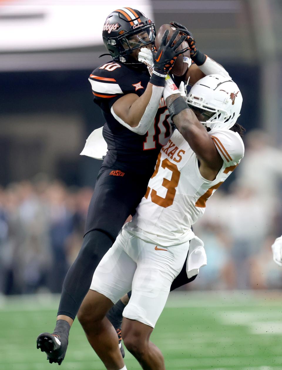 Oklahoma State's Rashod Owens (10) makes a catch as Texas' Jahdae Barron (23) defends in the first half of the Big 12 Football Championship game between the Oklahoma State University Cowboys and the Texas Longhorns at the AT&T Stadium in Arlington, Texas, Saturday, Dec. 2, 2023.
