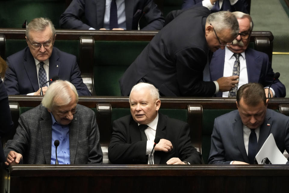 Jaroslaw Kaczynski, center, leader of Poland's right-wing Law and Justice party arrives for a speech of newly elected Poland's Prime Minister Donald Tusk at the parliament in Warsaw, Poland, Tuesday Dec. 12, 2023. (AP Photo/Czarek Sokolowski)