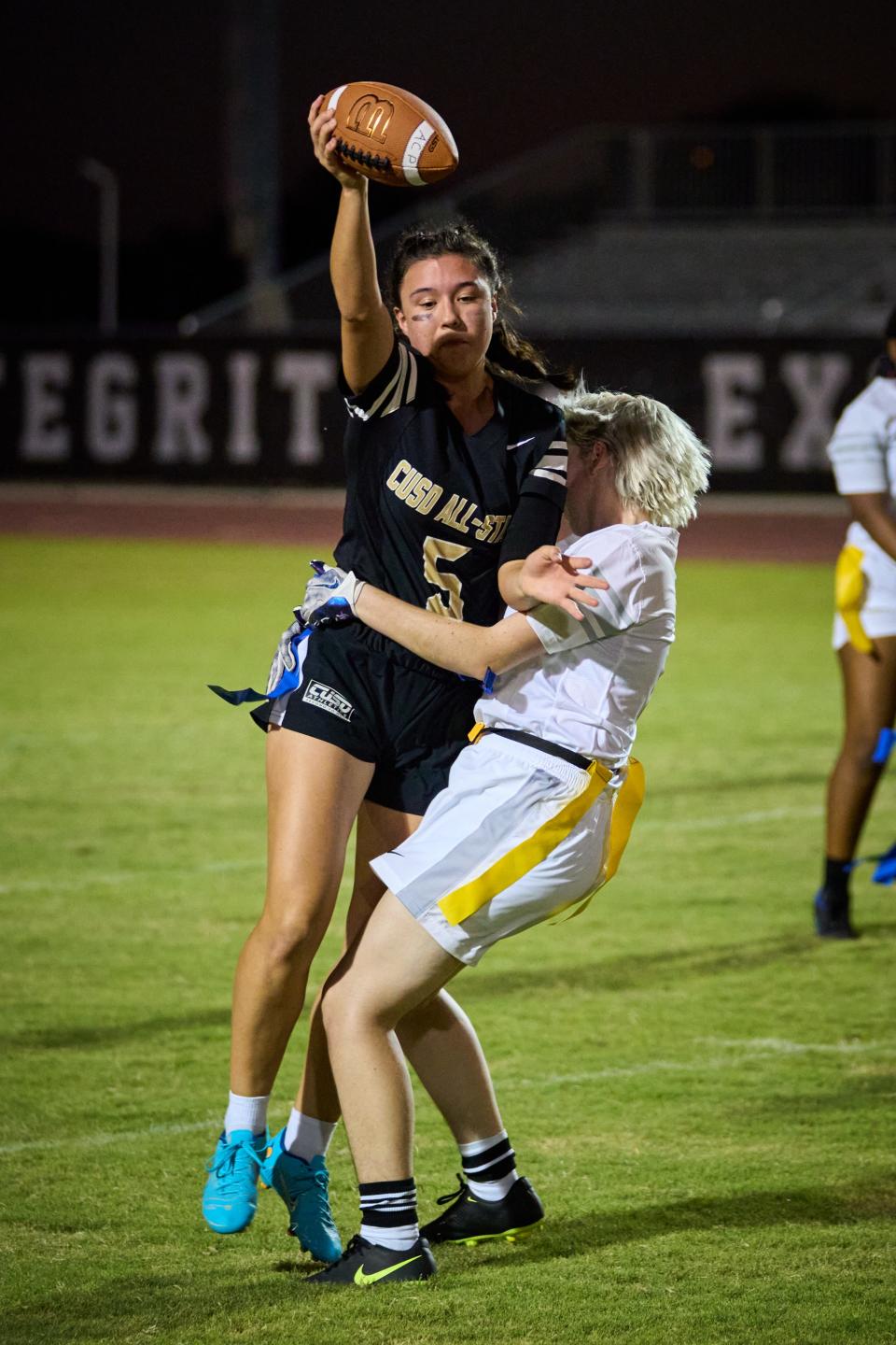 Sep 1, 2022; Chandler, Arizona, USA; Arizona College Prep Knights senior running back Regan Burke (5) holds the ball above her had as she collides with and has her flag pulled Casteel Colts senior linebacker Olivia Schrempp (6) by at the Hamilton High School football field. Mandatory Credit: Alex Gould/The Republic