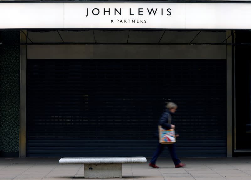 A woman walks past a temporarily closed John Lewis department store on Oxford Street in London