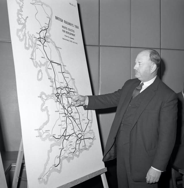 Richard Beeching looking at a large map, showing how British Rail trunk routes might look in 1984  (PA)