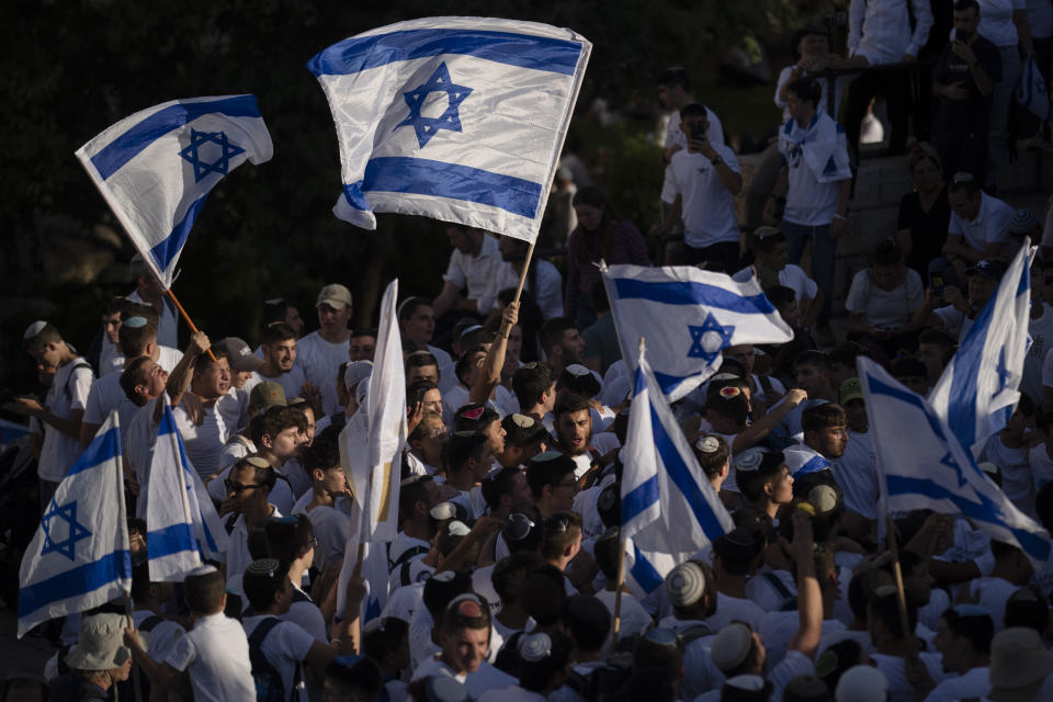 Israelis wave national flags during a march marking Jerusalem Day, an Israeli holiday celebrating the capture of east Jerusalem in the 1967 Mideast war, in front of the Damascus Gate of Jerusalem's Old City, Wednesday, June 5, 2024. Thousands of mostly ultranationalist Israelis are taking part in an annual march through a dense Palestinian neighborhood of Jerusalem’s Old City. (AP Photo/Leo Correa)