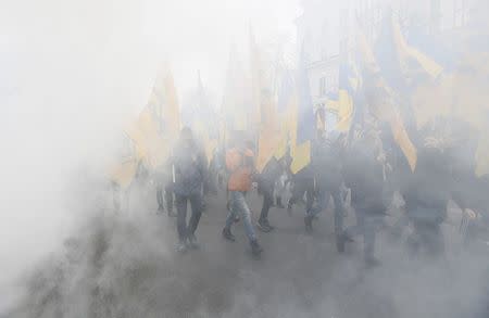 Activists of nationalist groups and their supporters are seen through the smoke from flares during the so-called March of Dignity, marking the third anniversary of the 2014 Ukrainian pro-European Union (EU) mass protests, in Kiev, Ukraine, February 22, 2017. REUTERS/Valentyn Ogirenko