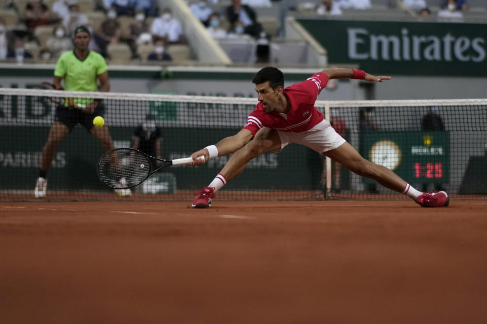 Serbia's Novak Djokovic stretches to return the ball to Spain's Rafael Nadal during their semifinal match of the French Open tennis tournament at the Roland Garros stadium Friday, June 11, 2021 in Paris. (AP Photo/Christophe Ena)