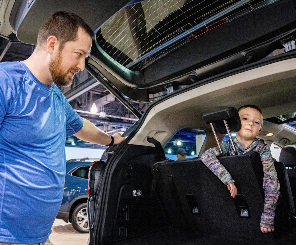 5-year-old Benson McDonald and his father Jordan McDonald of Waukesha look at the different features of cars at the Milwaukee Auto Show on Saturday February 25, 2023 at the Wisconsin Center in Milwaukee, Wis.