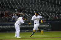 Oakland Athletics' J.D. Davis, right, celebrates with third base coach Eric Martins after hitting a solo home run against Cleveland Guardians pitcher Logan Allen during the fourth inning of a baseball game Friday, March 29, 2024, in Oakland, Calif. (AP Photo/Godofredo A. Vásquez)