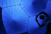 A woman takes a photograph inside Exxopolis, an inflatable walk-in luminarium at Grand Park in Los Angeles, California, September 7, 2013. The inflatable walk-in luminarium, designed by Architects of Air, creates a maze of winding paths and domes featuring Islamic architecture, Archimedean solids, and Gothic cathedral designs. REUTERS/Jonathan Alcorn (UNITED STATES - Tags: SOCIETY)