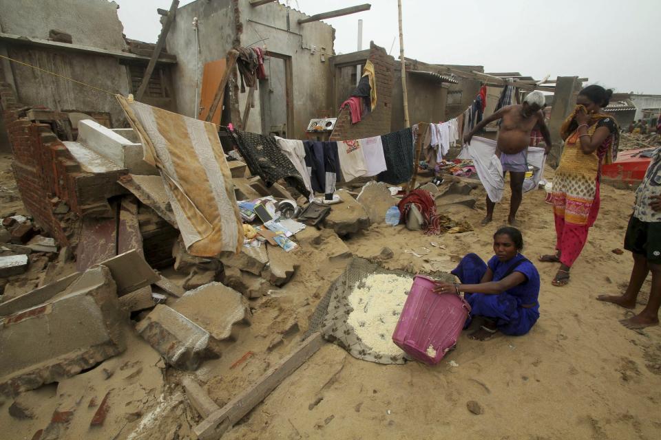 Locals stand by damage made by Cyclone Fani in the Penthakata fishing village of Puri, in the eastern Indian state of Orissa, Saturday, May 4, 2019. A mammoth preparation exercise that included the evacuation of more than 1 million people appears to have spared India a devastating death toll from one of the biggest storms in decades, though the full extent of the damage was yet to be known, officials said Saturday. (AP Photo)