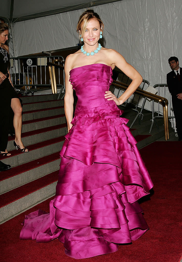 A celebrity wearing a strapless tiered gown paired with a chunky necklace at an event