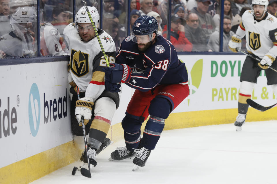 Columbus Blue Jackets' Boone Jenner, right, checks Vegas Golden Knights' William Carrier during the third period of an NHL hockey game on Monday, Nov. 28, 2022, in Columbus, Ohio. (AP Photo/Jay LaPrete)