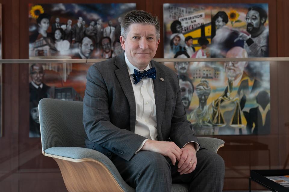 Jeffrey Jackson, dean of the Washburn University School of Law, sits Tuesday afternoon in front of murals representing the Brown v. Board of Education case in which Washburn Law played a key role.