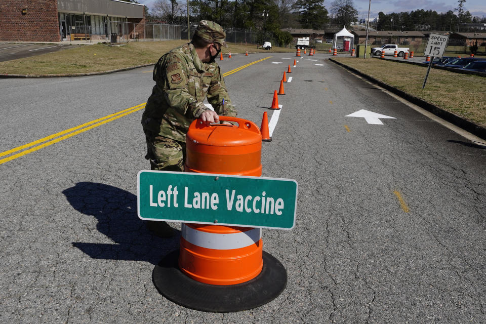 Georgia Air National Guardsman Sgt. Owen Bock works to set up a mass vaccination site at the Macon State Farmers Market on Friday, Feb. 19, 2021, in Atlanta. Officials say starting Monday they plan to vaccinate 1,100 a day at the site. (AP Photo/John Bazemore)