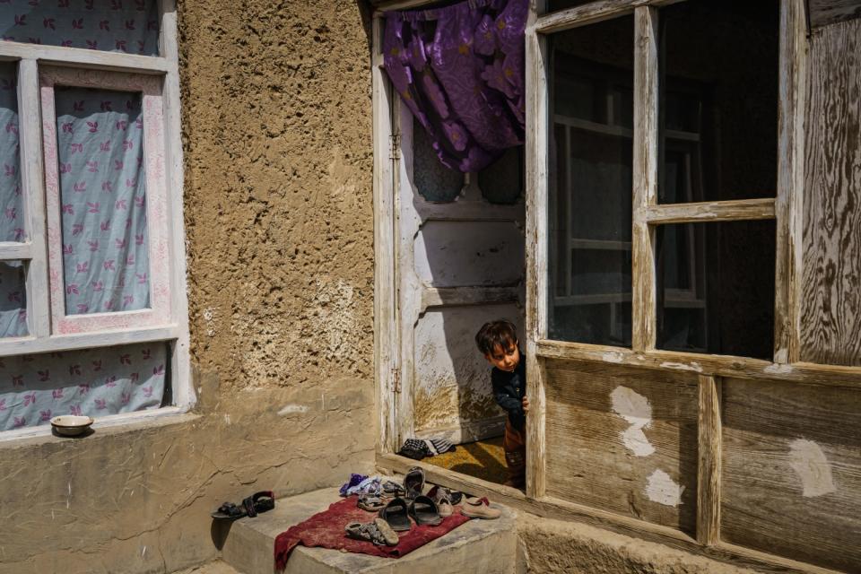 A child peeks out of a doorway.