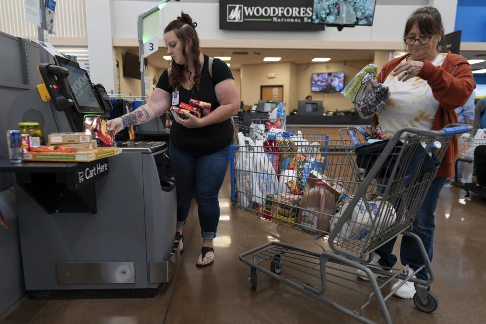 Jesse Johnson, left, of the Family Resource Center helps her client Jodi Ferdinandsen check out at Walmart in Findlay, Ohio, Thursday, Oct. 12, 2023. Peer support services for people in recovery are a major component of Hancock County's strategy for addressing the opioid epidemic. (AP Photo/Carolyn Kaster)