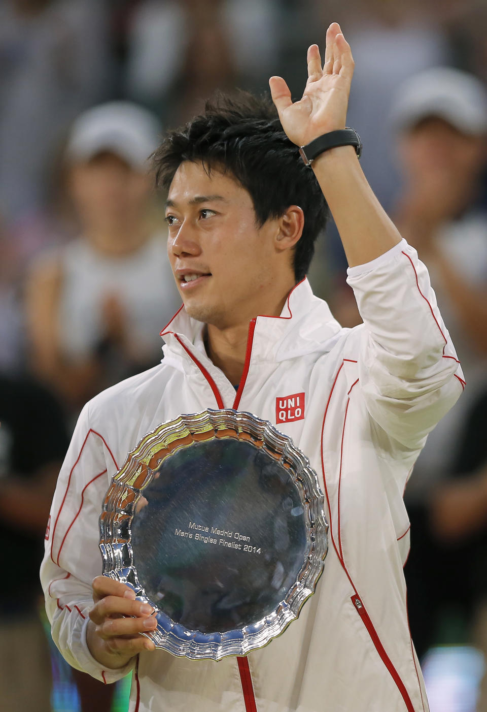 Kei Nishikori from Japan holds his trophy while waving after his Madrid Open tennis tournament final match against Rafael Nadal from Spain in Madrid, Spain, Sunday, May 11, 2014. (AP Photo/Andres Kudacki)