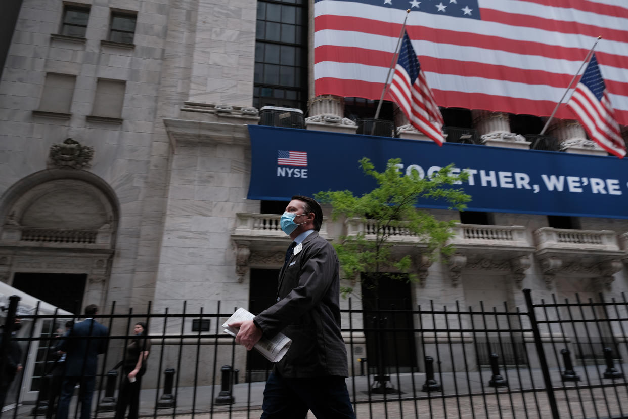 NEW YORK, NEW YORK - MAY 26: A trader walks by the New York Stock Exchange (NYSE) on the first day that traders are allowed back onto the historic floor of the exchange on May 26, 2020 in New York City. While only a small number of traders will be returning at this time, those that do will have to take temperature checks and wear face masks at all times while on the floor. The Dow rose over 600 points in morning trading as investors see economic activity in America picking up (Photo by Spencer Platt/Getty Images)