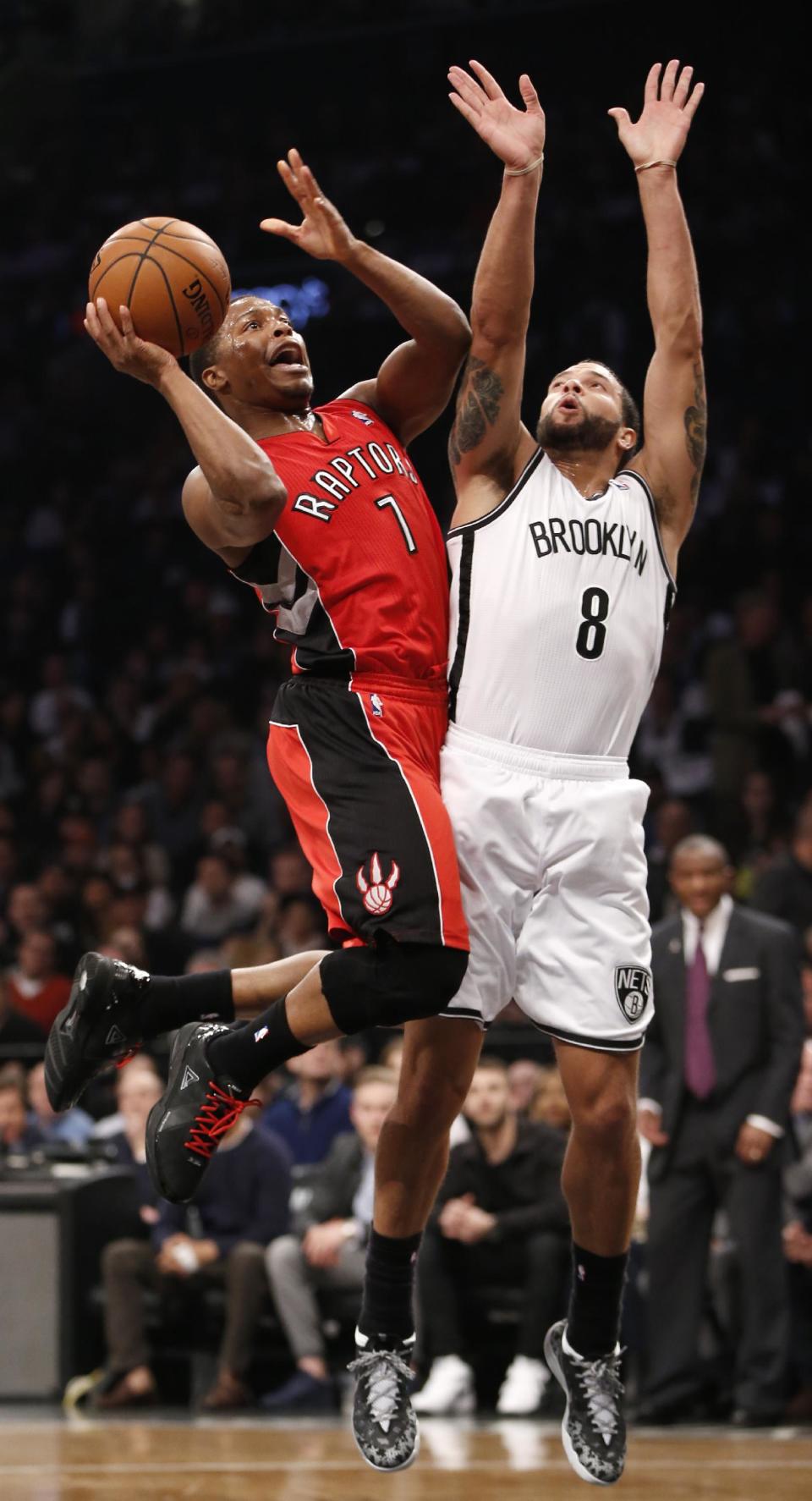 Kyle Lowry (7), de los Raptors de Toronto, intenta encestar frente a Deron Williams (8), de los Nets de Brooklyn, en la primera mitad del cuarto partido de la serie de primera ronda de playoffs de NBA en el Barclays Center, el domingo 27 de abril de 2014, en Nueva York. Los Raptors ganaron 87-79 para igualar la serie 2-2. (Foto AP/Kathy Willens)