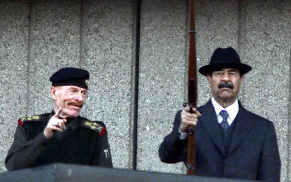 Al-Douri at a military parade in Baghdad with Saddam Hussein in 2000 - Karim Sahib/AFP via Getty Images