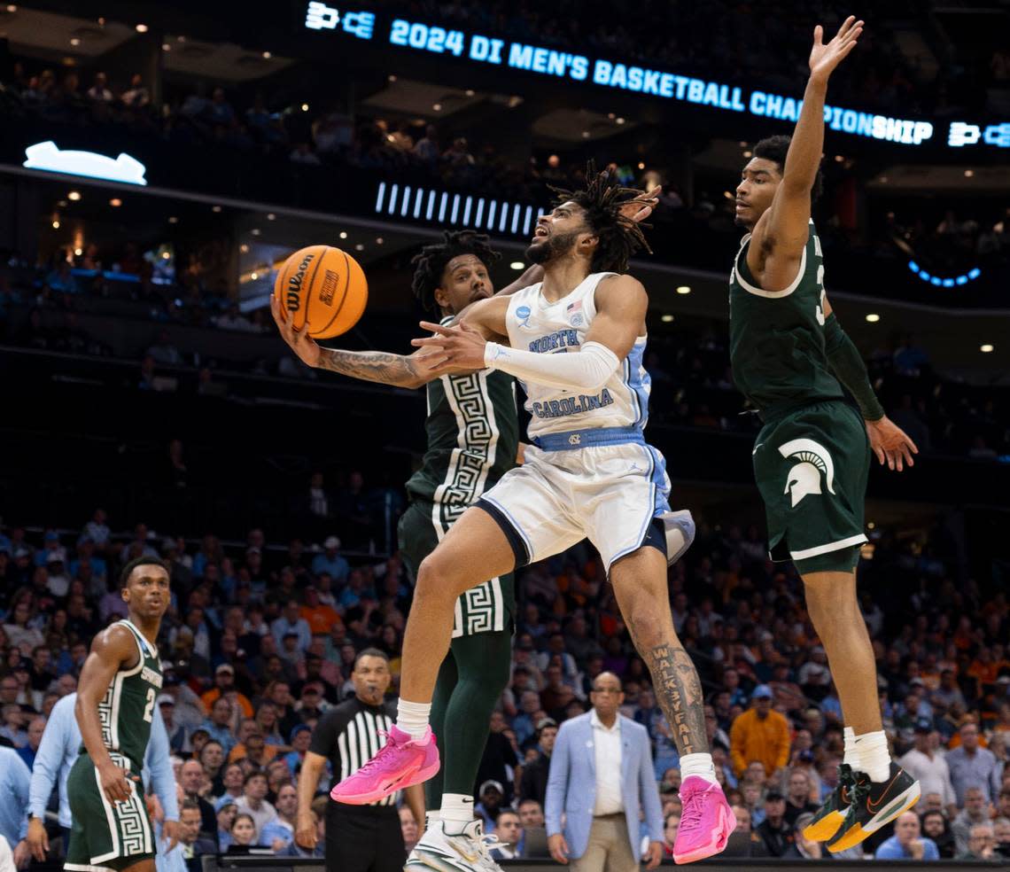 North Carolina’s R.J. Davis (4) drives to the basket against Michigan State’s A.J. Hoggard (11) and Jaden Akins (3) during the second half on Saturday, March 23, 2024, in the second round of the NCAA Tournament at Spectrum Center in Charlotte, N.C. Davis scored 20 pointing lead the Tar Heels to an 85-69 victory.