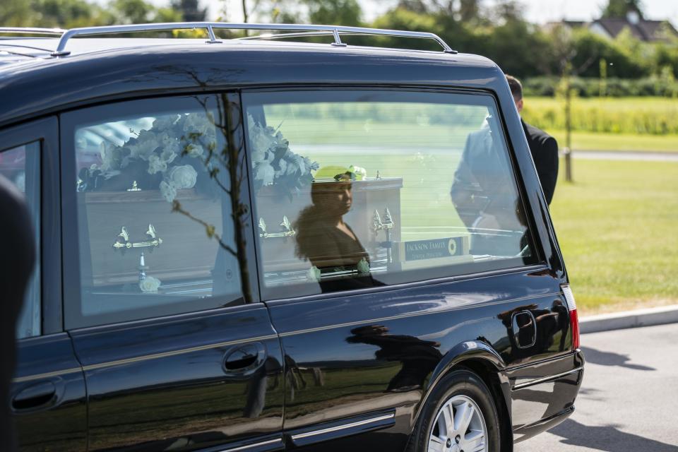 A mourner looks at the funeral cortege of Jodon Gait, a healthcare assistant at Worcestershire Royal Hospital who died of COVID-19, as it passes through a socially distanced guard of honour made by his friends and colleagues, at his funeral at The Vale Crematorium in Fladbury, Worcestershire. Jackson Family Funeral Directors, LT & R Vowles coffin manufacturers and The Vale Crematorium have provided their services for free in honour of Jodon Gait, who has no UK family.