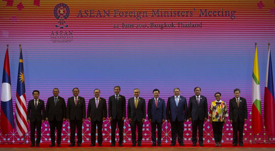 Foreign ministers of the Association of Southeast Asian Nations (ASEAN) from left, Laos Foreign Minister Saleumxay Kommasith, Malaysia Foreign Minister Saifuddin Abdullah, Myanmar Minister of State for Foreign Affaires Kyaw Tin, Philippines Foreign Affaires Secretary Teodoro Locsin Jr., Singapore Foreign Minister Vivian Balakrishnan, Thailand Foreign Minister Don Pramudwinai, Vietnam Deputy Prime Minister and Foreign Minister Pham Binh Minh, Brunei Second Minister of Foreign affaires and Trade Erywan Yusof, Cambodia Foreign Minister Prak Sokhonn, Indonesia Foreign Minister Retno Marsudi and ASEAN Secretary-General Dato Lim Jock Hoi pose for a group photo during the ASEAN Foreign Ministers' meeting in Bangkok, Thailand, Saturday, June 22, 2019. (AP Photo/Gemunu Amarasinghe)