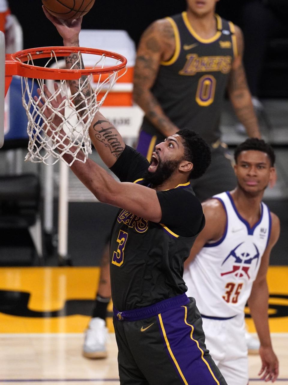 Lakers forward Anthony Davis shoots as Denver Nuggets guard PJ Dozier watches.