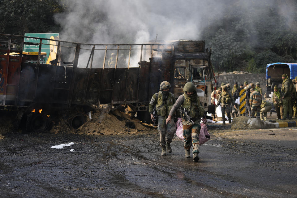 Indian army soldiers carry belongings of suspected rebels after a gunfight at Nagrota, on the Jammu-Srinagar highway, Indian-controlled Kashmir, Wednesday, Dec. 28, 2022. A top police officer, Mukesh Singh, said troops intercepted a truck in the outskirts of Jammu city early Wednesday following its “unusual movement” on a highway. As the troops began searching the truck, gunfire came from inside it, to which the troops retaliated, leading to a gunfight killing four suspected militants, Singh told reporters. (AP Photo/Channi Anand)