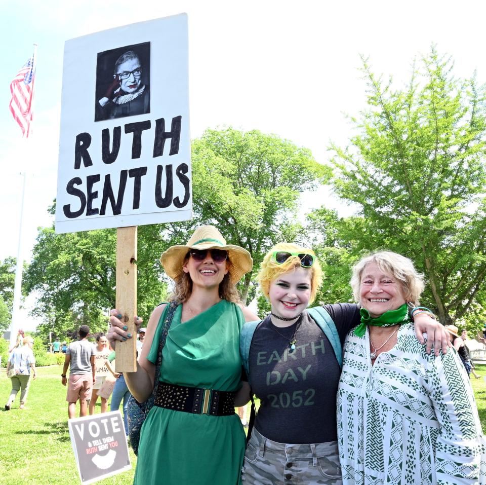 At the rally on the Falmouth Village Green on Saturday to protest the Supreme Court's decision overturning Roe v. Wade, Carol Strojny of Falmouth (right) is joined by her daughter, Sarah Fenton (left) and granddaughter Gracie Howes, 17, after an emotional explanation how she had and abortion back in the 70s.