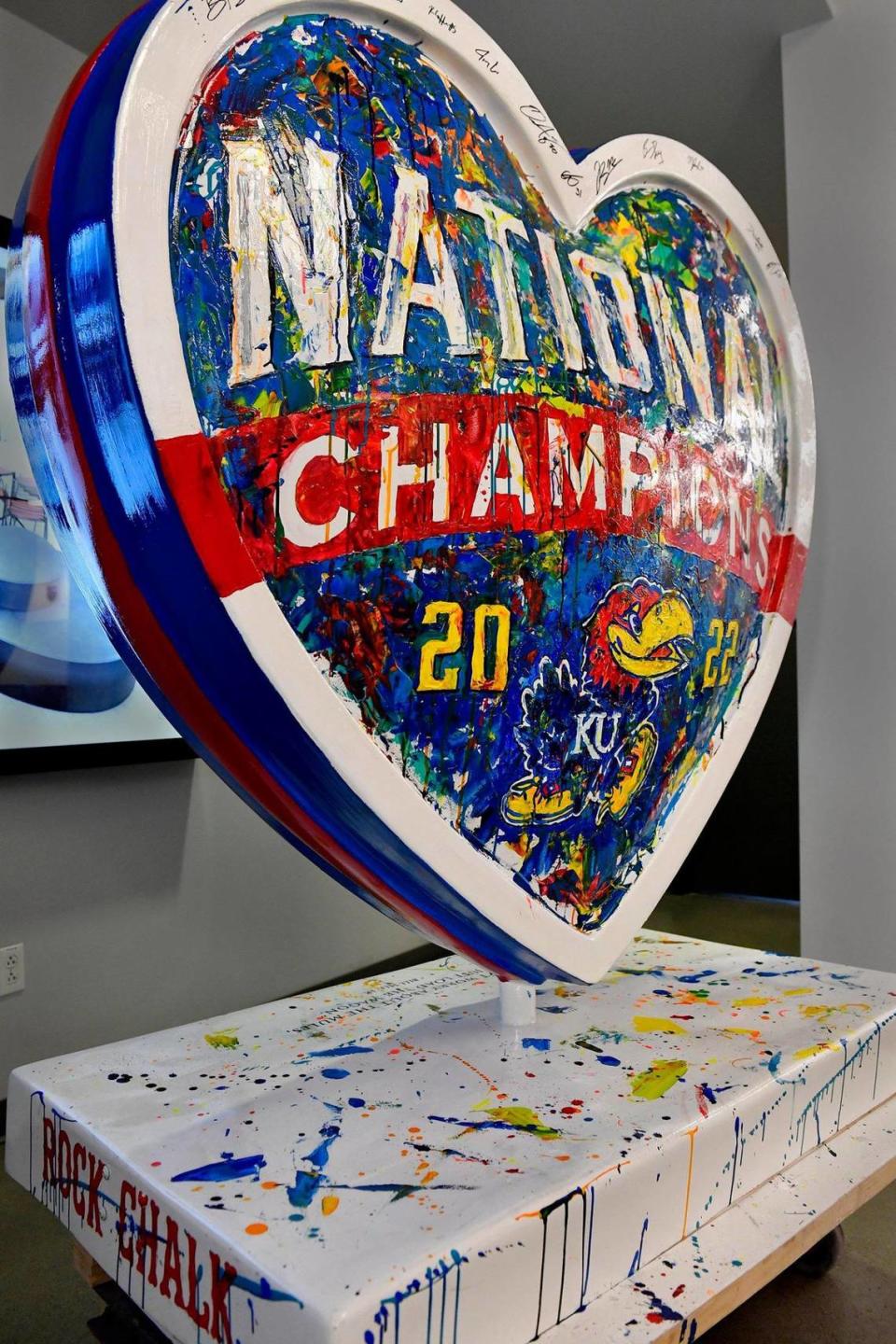 Artist Megh Knappenberger spoke Wednesday about creating “National Champions” her piece celebrating the KU Jayhawks basketball team’s recent NCAA championship victory. It took Knappenberger, a KU graduate, about three weeks to complete the peice, which is the 156th heart for the Parade of Hearts project. Kansas coach Bill Self and the 2022 team autographed it before It was unveiled Wednesday at Dimensional Innovations, in Overland Park.