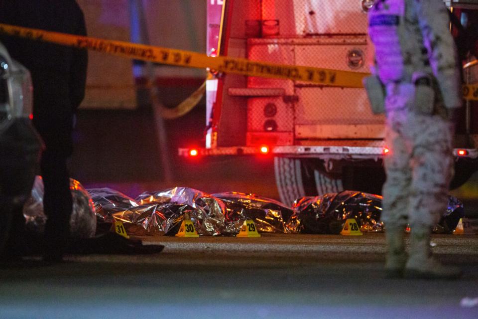 Bodies of migrants who died in a fire inside a Méxican migrant facility are lined up in the parking lot of the building in Juárez. Forty migrants died, Méxican officials said.