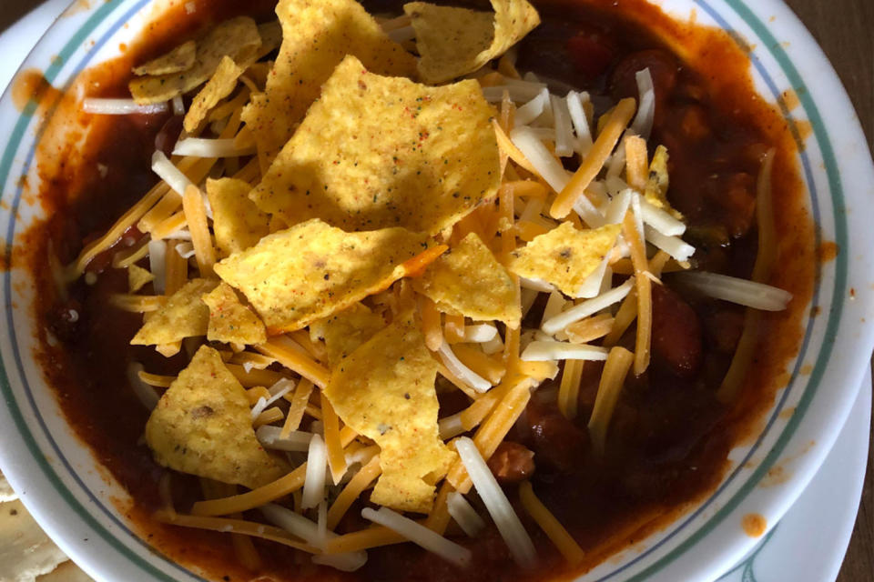 Canned chili topped with cheese and doritos