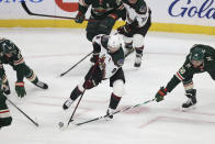 Arizona Coyotes right wing Clayton Keller (9) controls the puck next to Minnesota Wild left wing Jordan Greenway (18) during the first period of an NHL hockey game Tuesday, Nov. 30, 2021, in St. Paul, Minn. (AP Photo/Stacy Bengs)