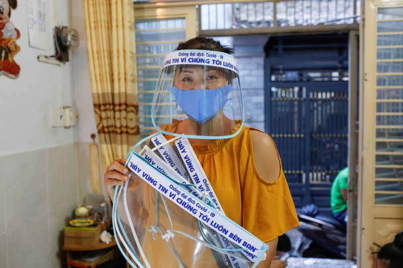 Quach My Linh, a hat vendor at Ba Chieu market, shows the plastic face masks with stickers that she makes to donate to hospitals during the outbreak of the coronavirus disease (COVID-19), in Ho Chi Minh, Vietnam