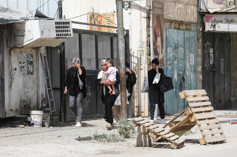 Palestinians walk, in Jenin