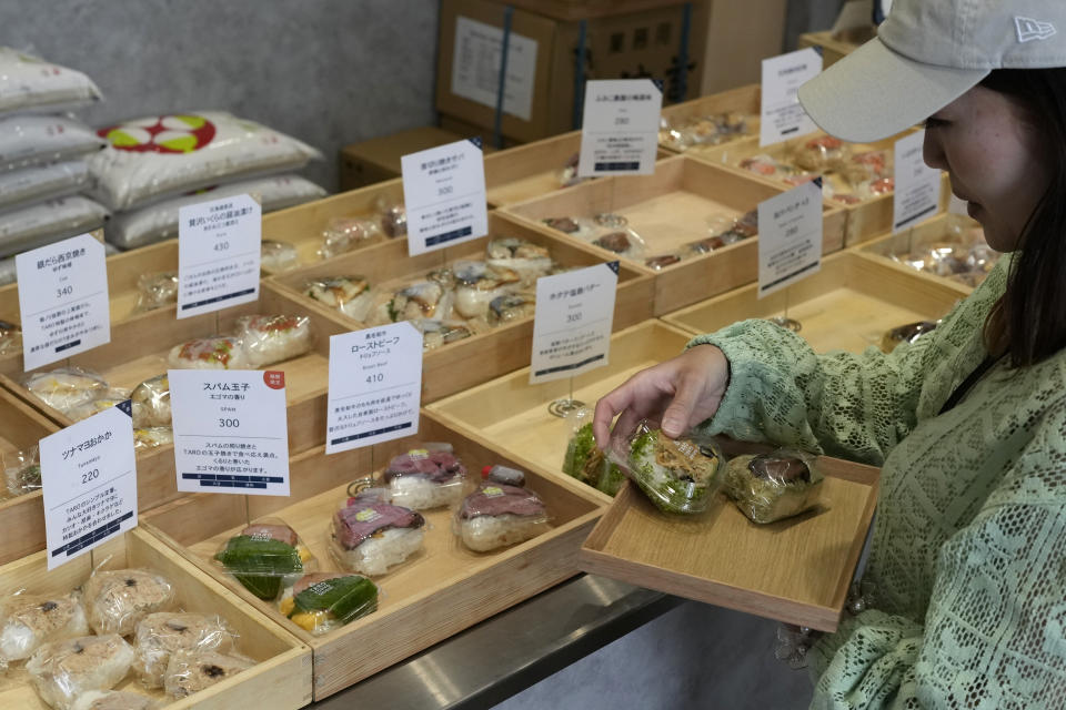 A customer buys onigiri, rice balls, at a Taro Tokyo Onigiri shop in Tokyo, on June 5, 2024. The word "onigiri" just became part of the Oxford English Dictionary this year. The humble sticky-rice ball, a mainstay of Japanese food, has entered the global lexicon. (AP Photo/Shuji Kajiyama)