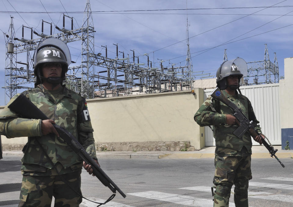 Military police stand guard outside Transportadora de Electricidad, the Spanish electricity grid’s Bolivian subsidiary, in Cochabamba, Bolivia, Tuesday, May 1, 2012. Bolivia's President Evo Morales says his government is completing the nationalization of the country's electricity industry by taking over its electrical grid from the Spanish-owned company, Red Electrica. (AP Photo)