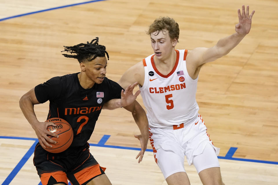 Miami guard Isaiah Wong (2) and Clemson forward Hunter Tyson (5) get tangled during the second half of an NCAA college basketball game in the second round of the Atlantic Coast Conference tournament in Greensboro, N.C., Wednesday, March 10, 2021. (AP Photo/Gerry Broome)