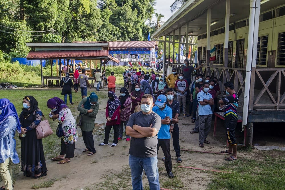 Voters wearing protective masks queue up to cast their votes during the Sabah state election in SK Pulau Gaya September 26, 2020. — Picture by Firdaus Latif